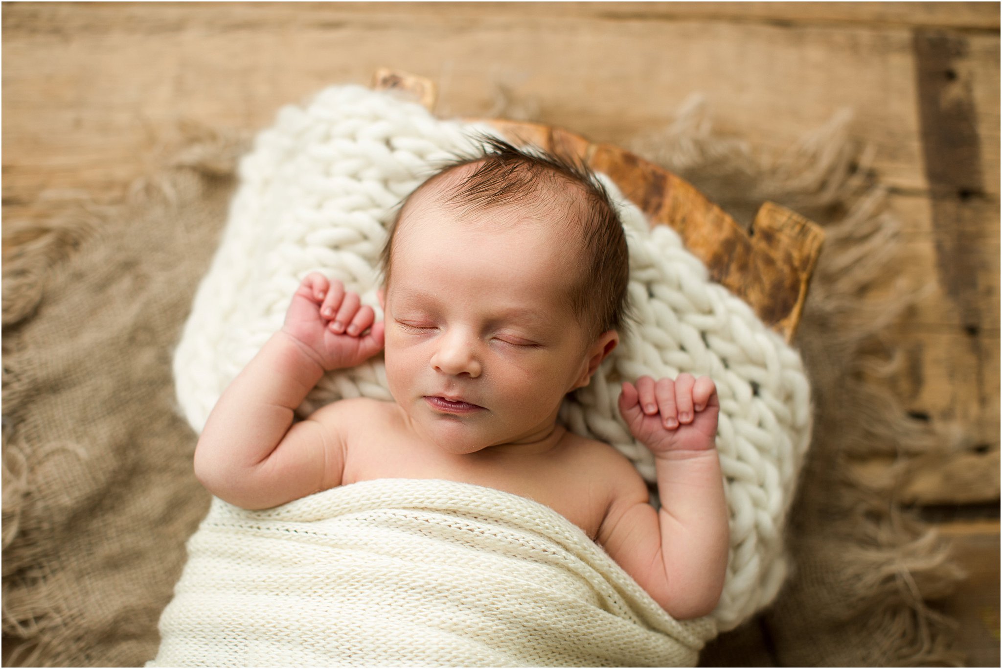 sleeping baby in wooden prop with knit layer