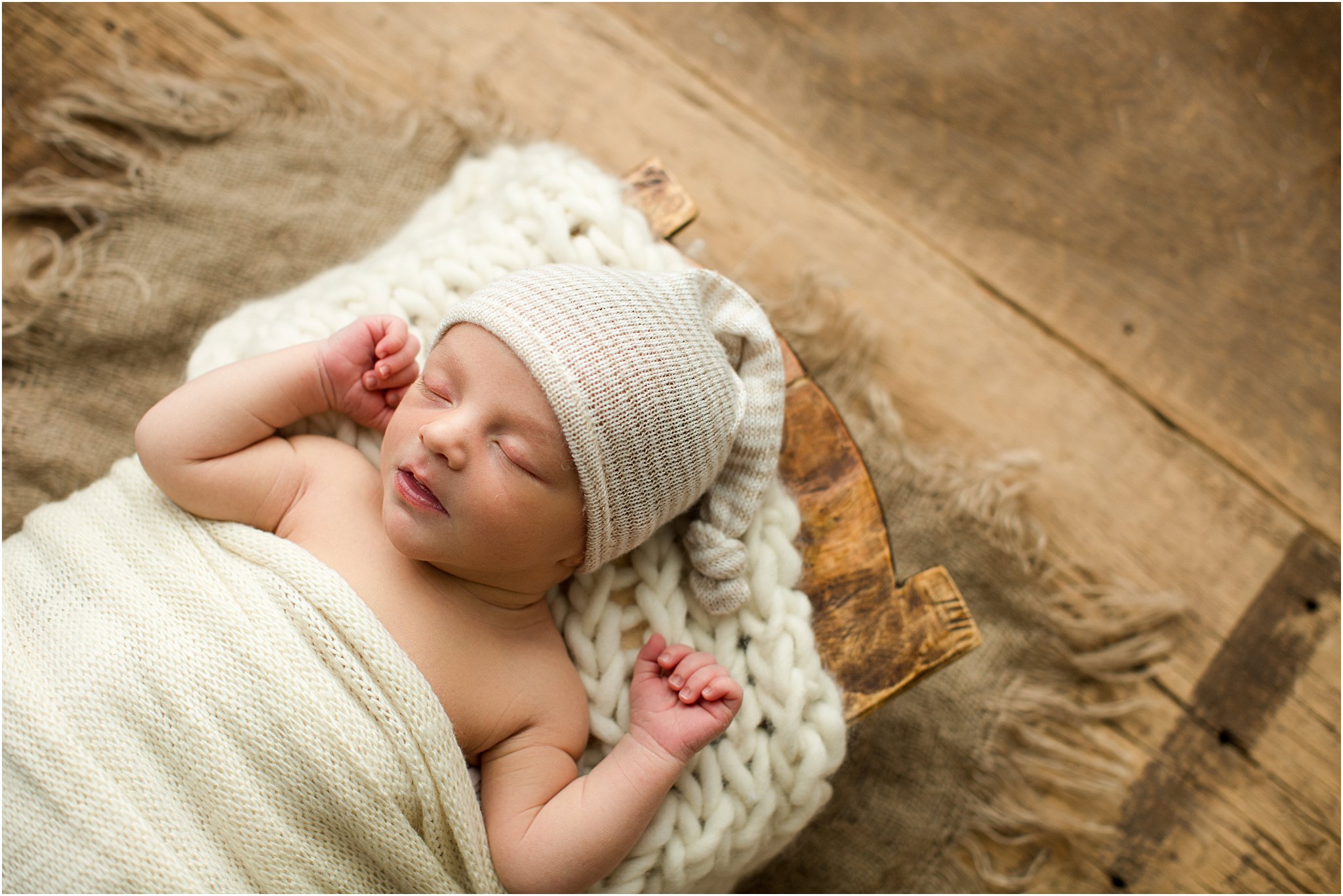 baby boy in cream sleeper hat