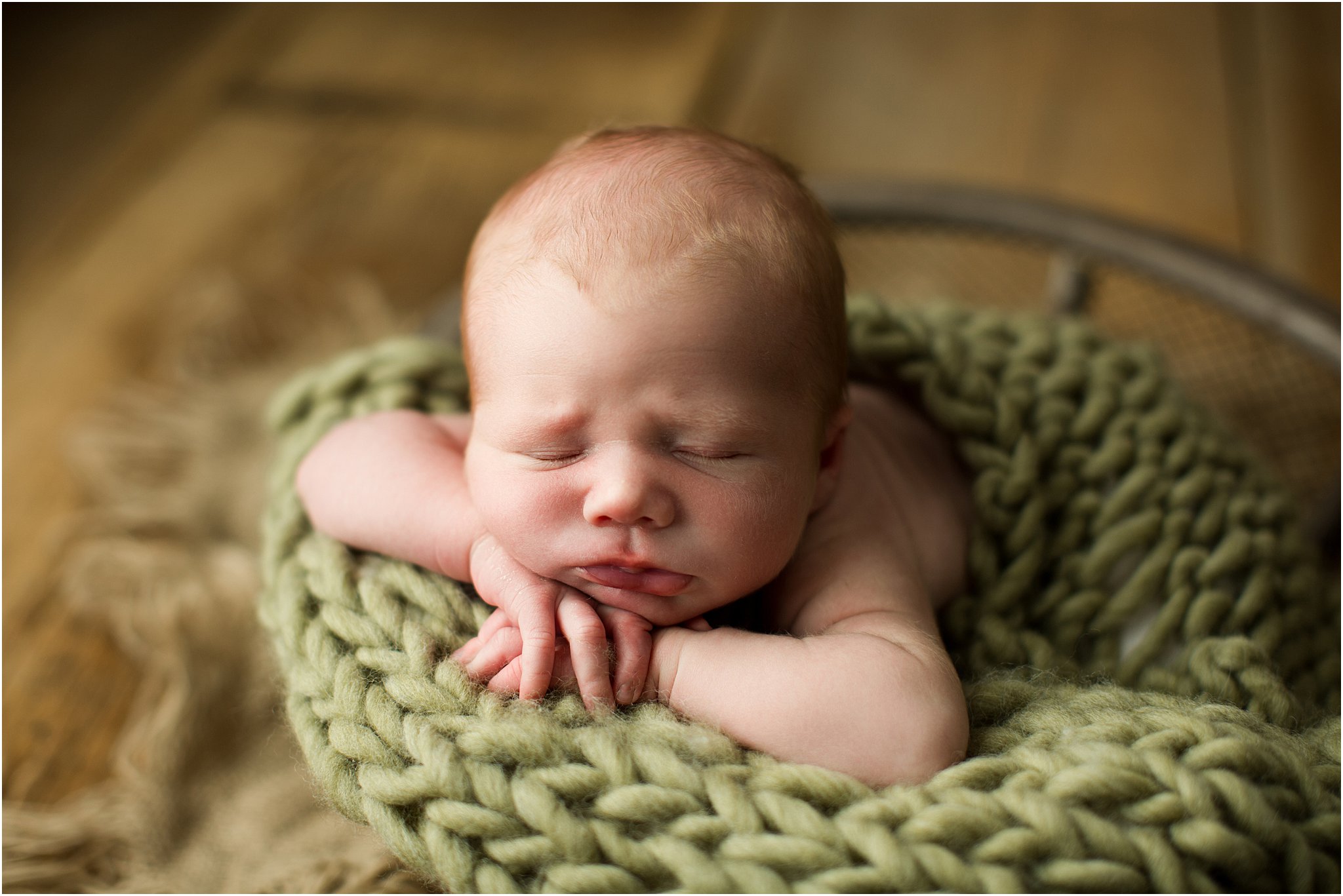 baby boy in wire mesh basket with green knit layer