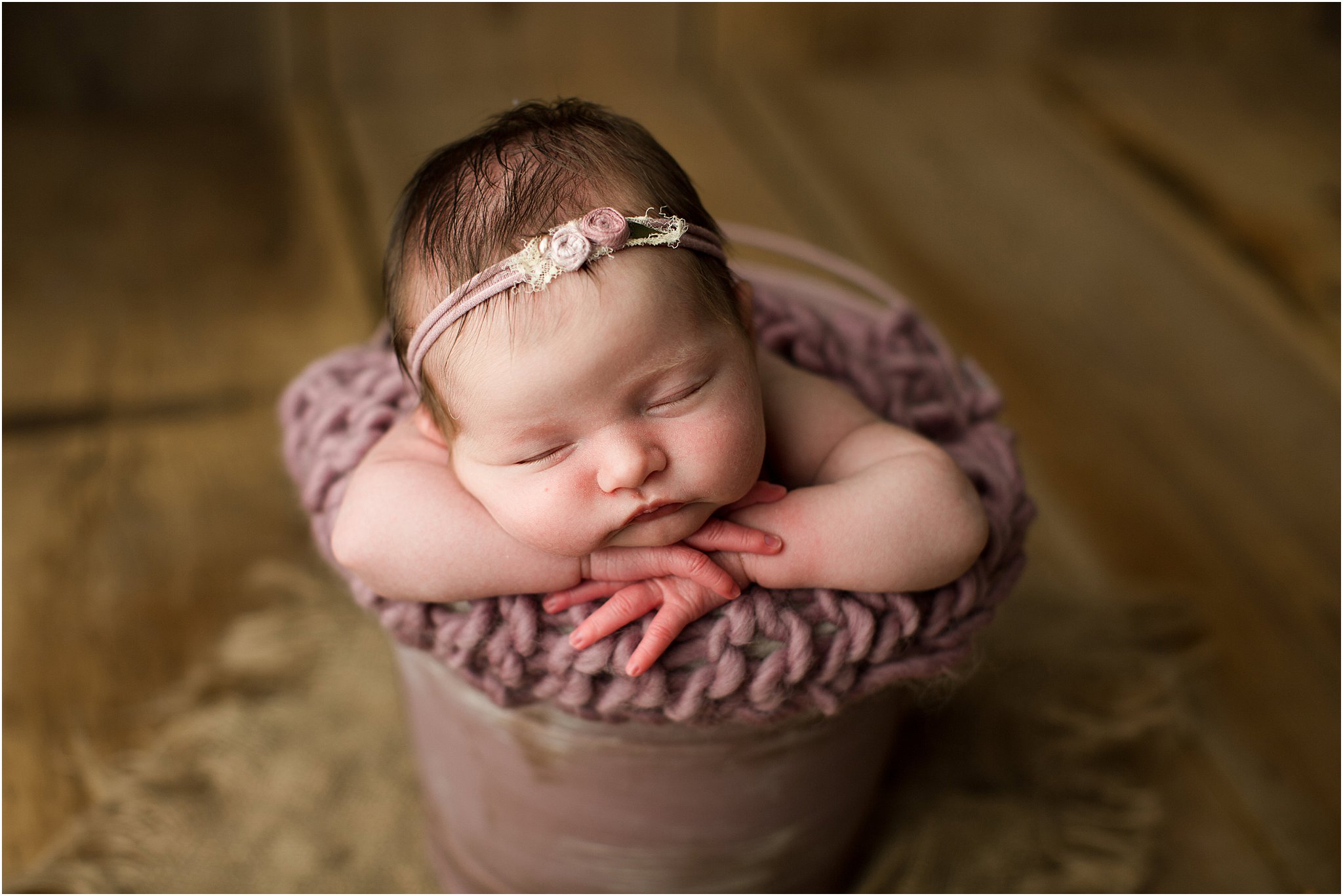 baby girl in mauve bucket with flower headband