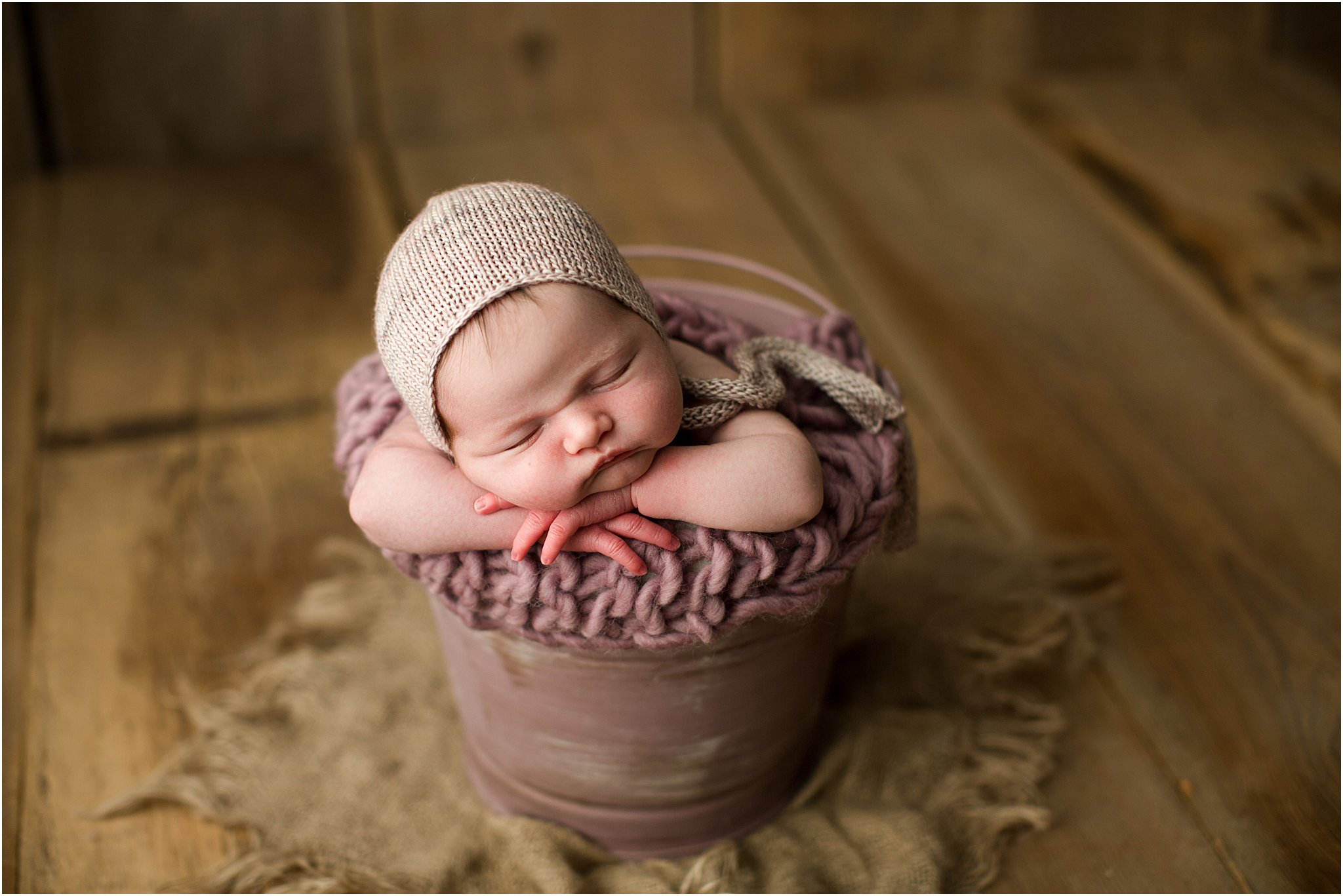 chubby newborn girl in a bucket on barnwood