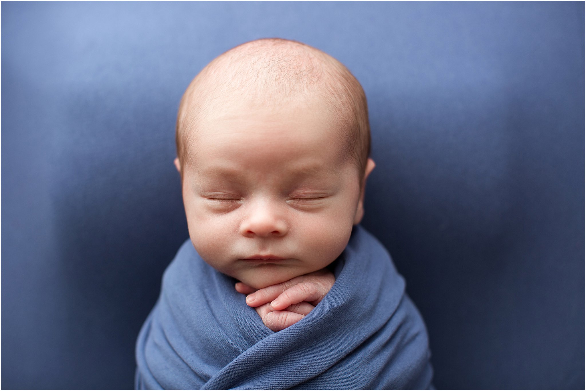 newborn baby boy wrapped in blue 