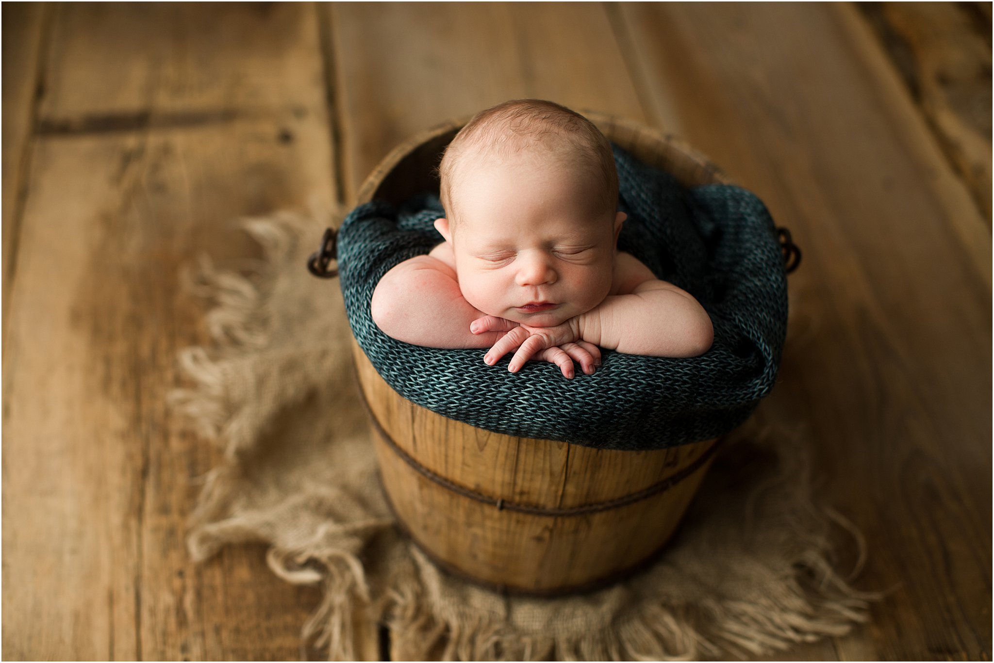 baby boy in wooden bucket