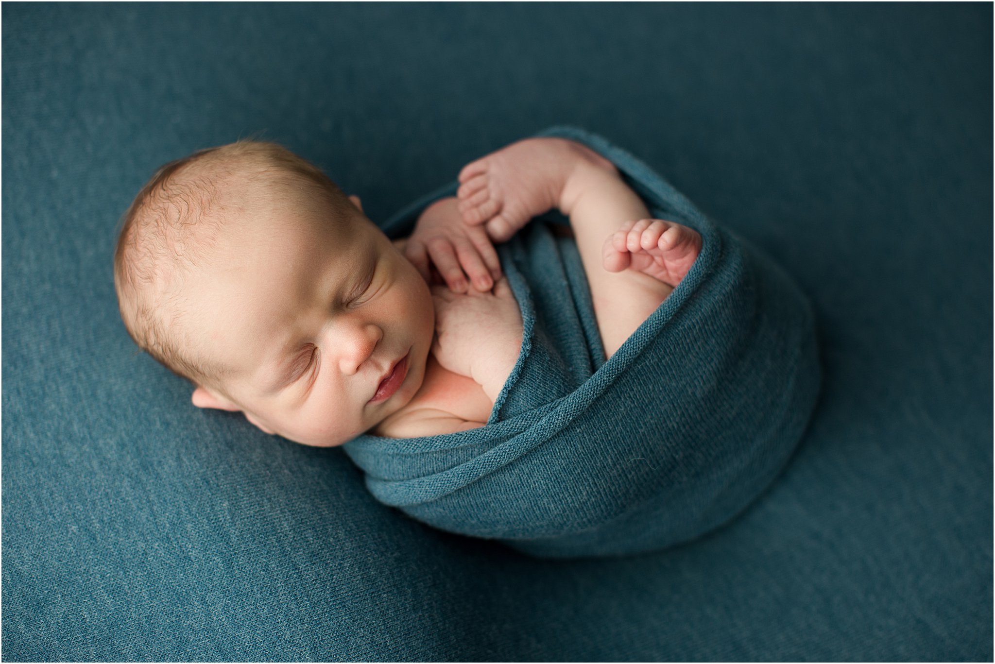 wrapped up baby in blue fabric