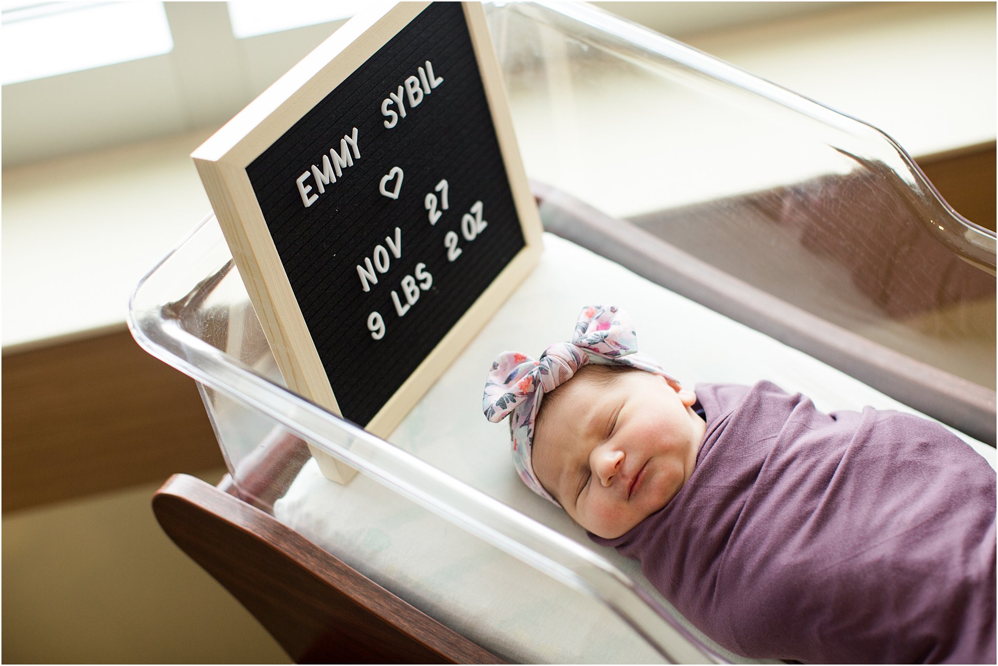 newborn girl with letterboard sign