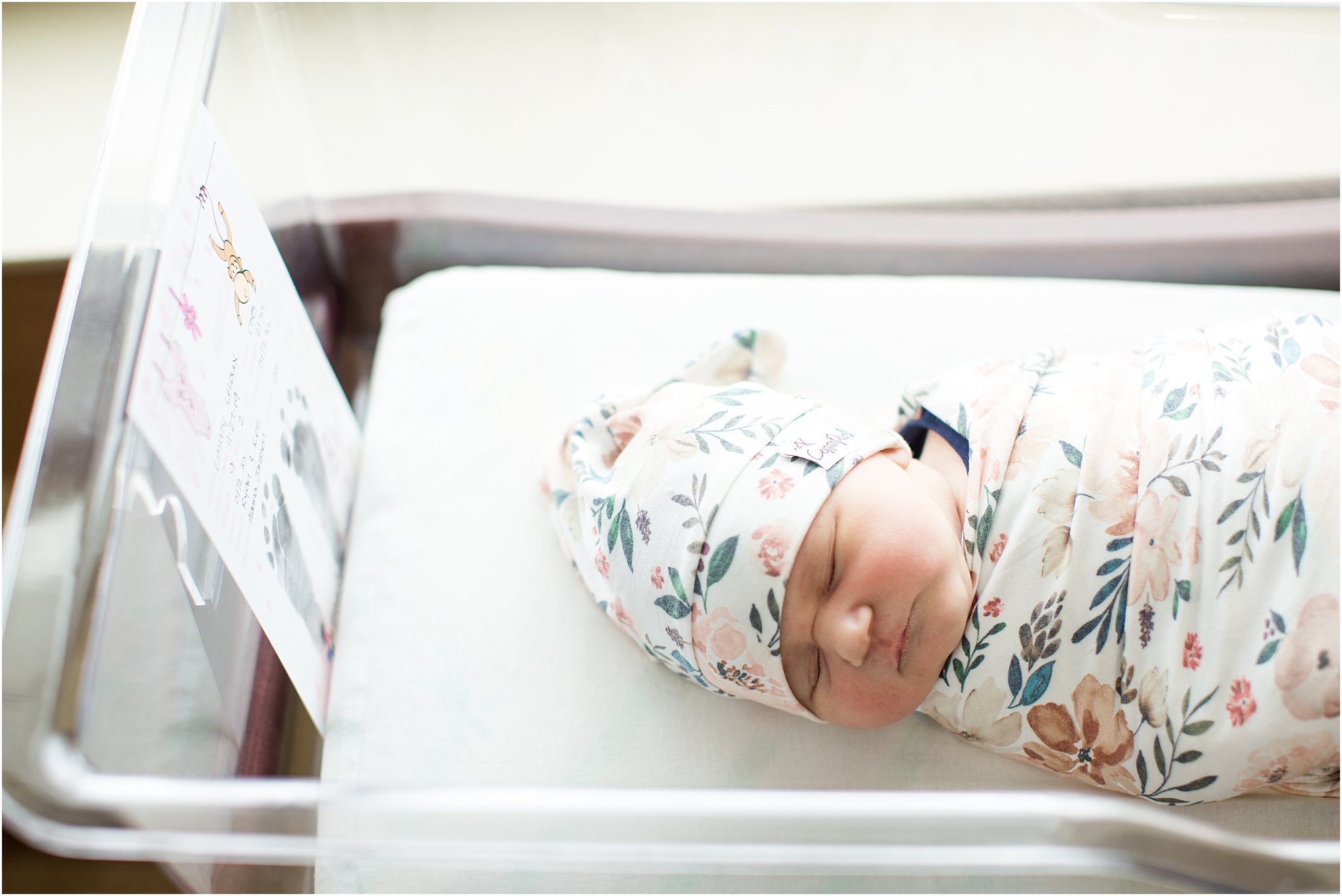 swaddled baby girl with knotted hat