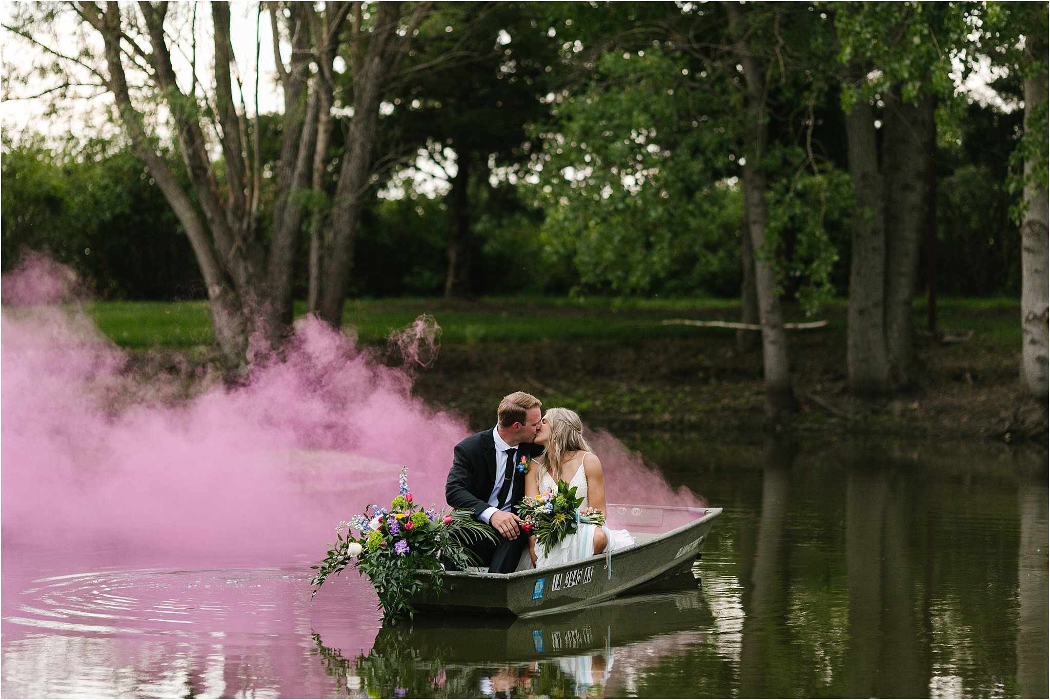 bride and groom kissing on boat with smoke